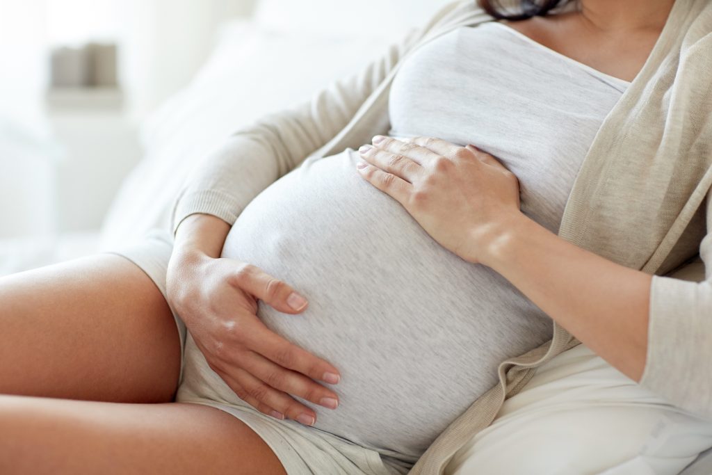 close up of pregnant woman lying in bed at home