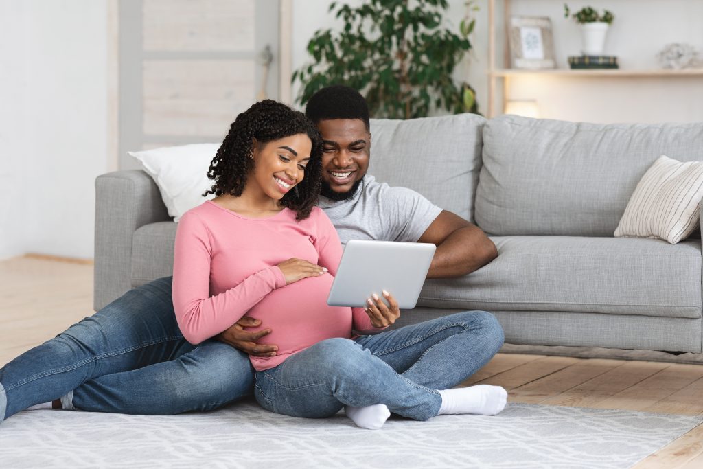 Pregnant woman and partner researching best products for after birth and breastfeeding